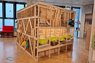 Viele der verbauten Holzelemente entstanden direkt im Ausstellungsraum. Hier können die Besucher*innen verschiedene Baumaterialien mit ihrer entsprechenden Klimabilanz erkunden. Diese Inhalte waren explizit von den Kindern erwünscht, die im Vorfeld an W