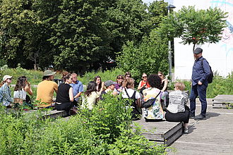 Die Studierenden vor dem temporären Standort für das Museum für zeitgenössische Kunst im Gespräch mit der verantwortlichen Kuratorin. © HTW Berlin / Thomas Kämpfe